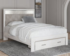 White panel bed with light gray upholstered headboard and footboard drawers on carpeted floor.