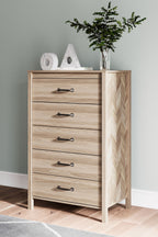 Tan five-drawer chest with black bar handles and chevron end panel