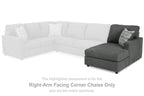 Sectional corner chaise with dark gray ottoman and patterned throw pillow