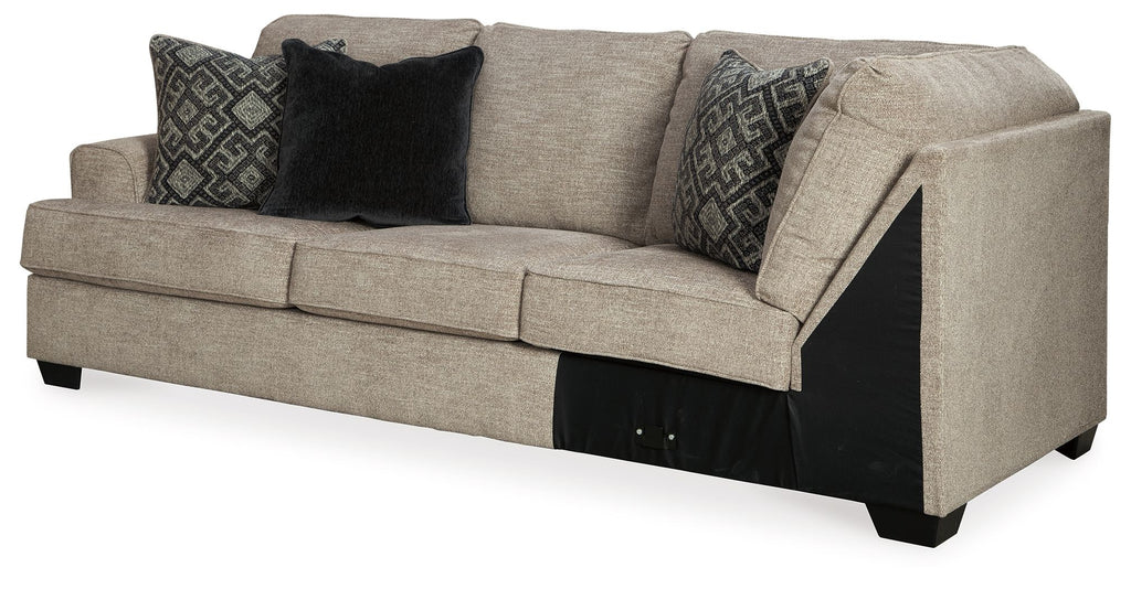 Stone gray sofa with left arm and upholstered cushions, dark patterned throw pillows