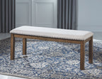 Upholstered dining bench with dark wood frame, nailhead trim, light seat cushion