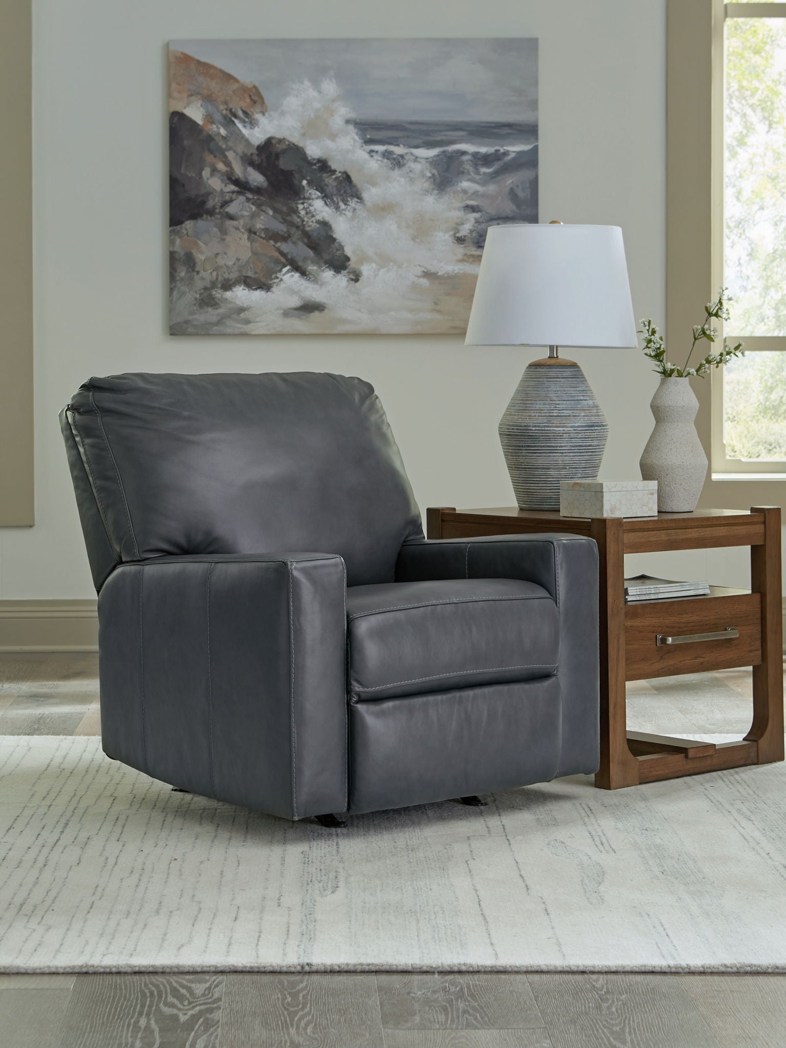 Dark gray leather-look rocker recliner chair with wide seat and padded backrest