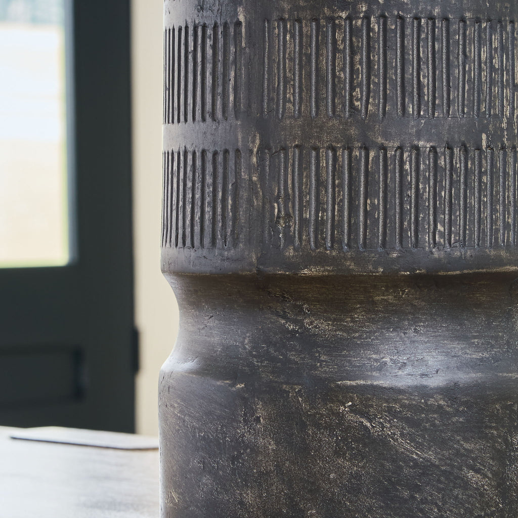 Beninworth vase close-up, black ribbed surface and worn pedestal base detail.