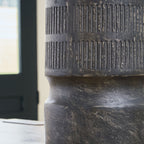 Beninworth vase close-up, black ribbed surface and worn pedestal base detail.