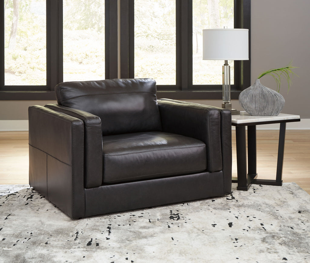 Black leather armchair with square arms and tufted cushion panels
