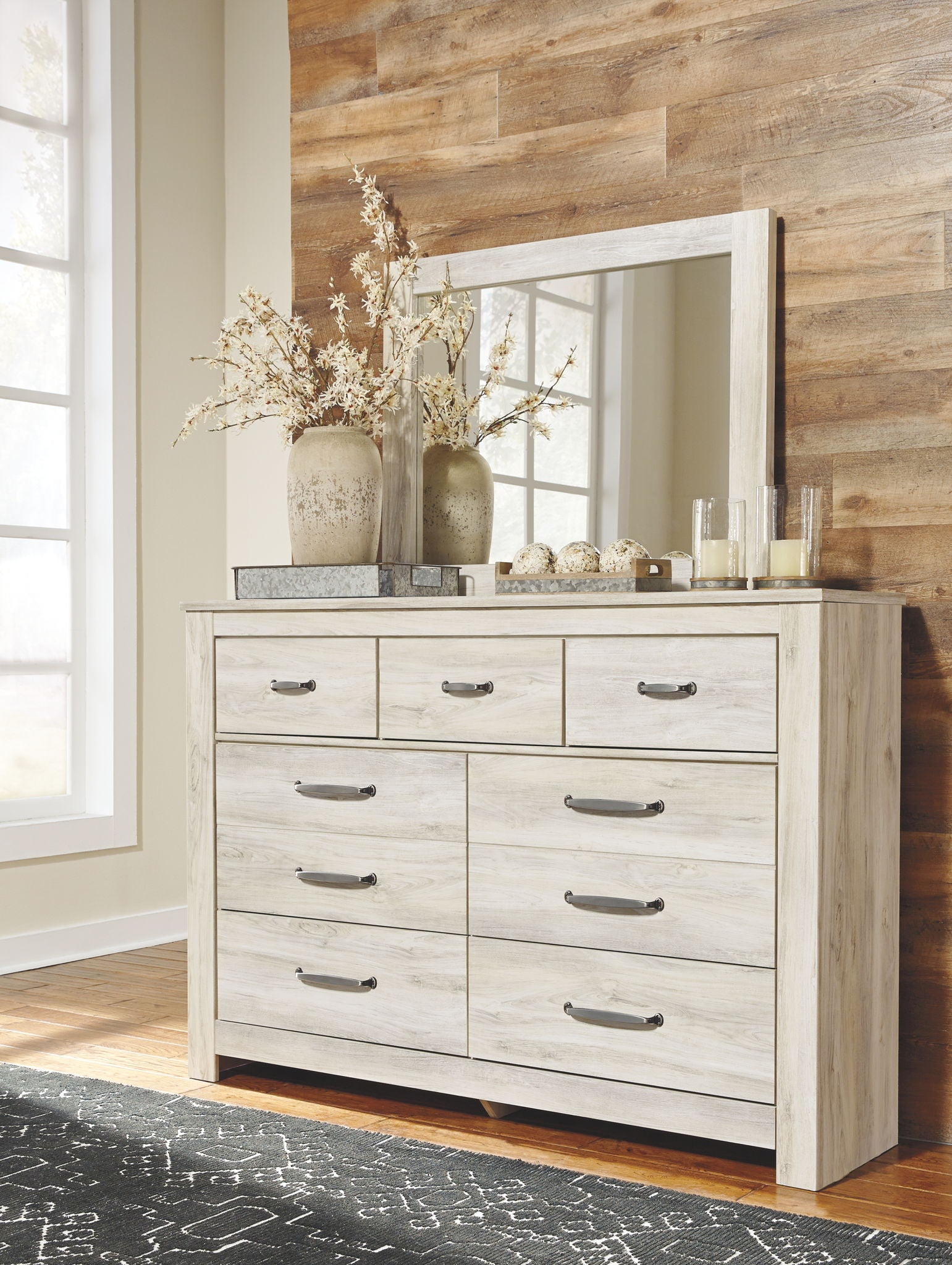 Light beige dresser with attached mirror; nine drawers with metal bar pulls