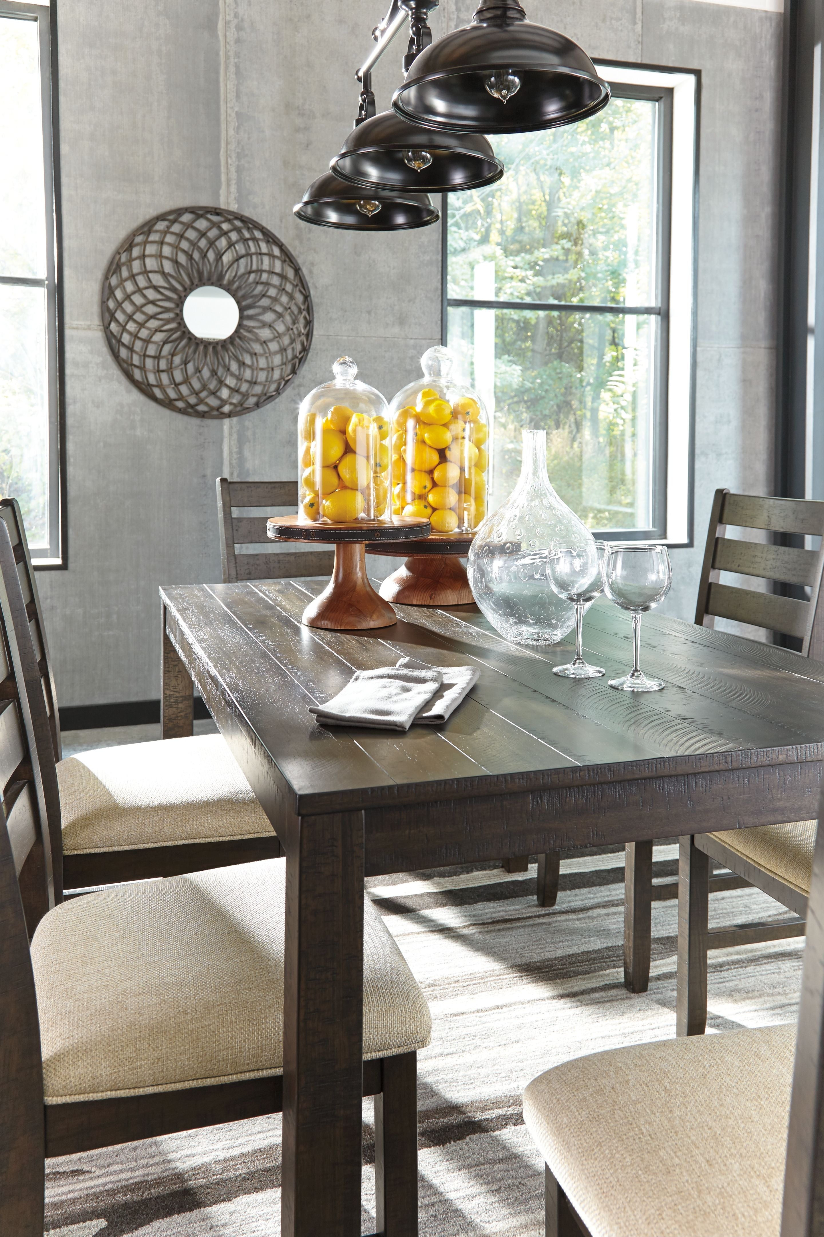Brown dining table with two beige-cushioned chairs and chair backs visible