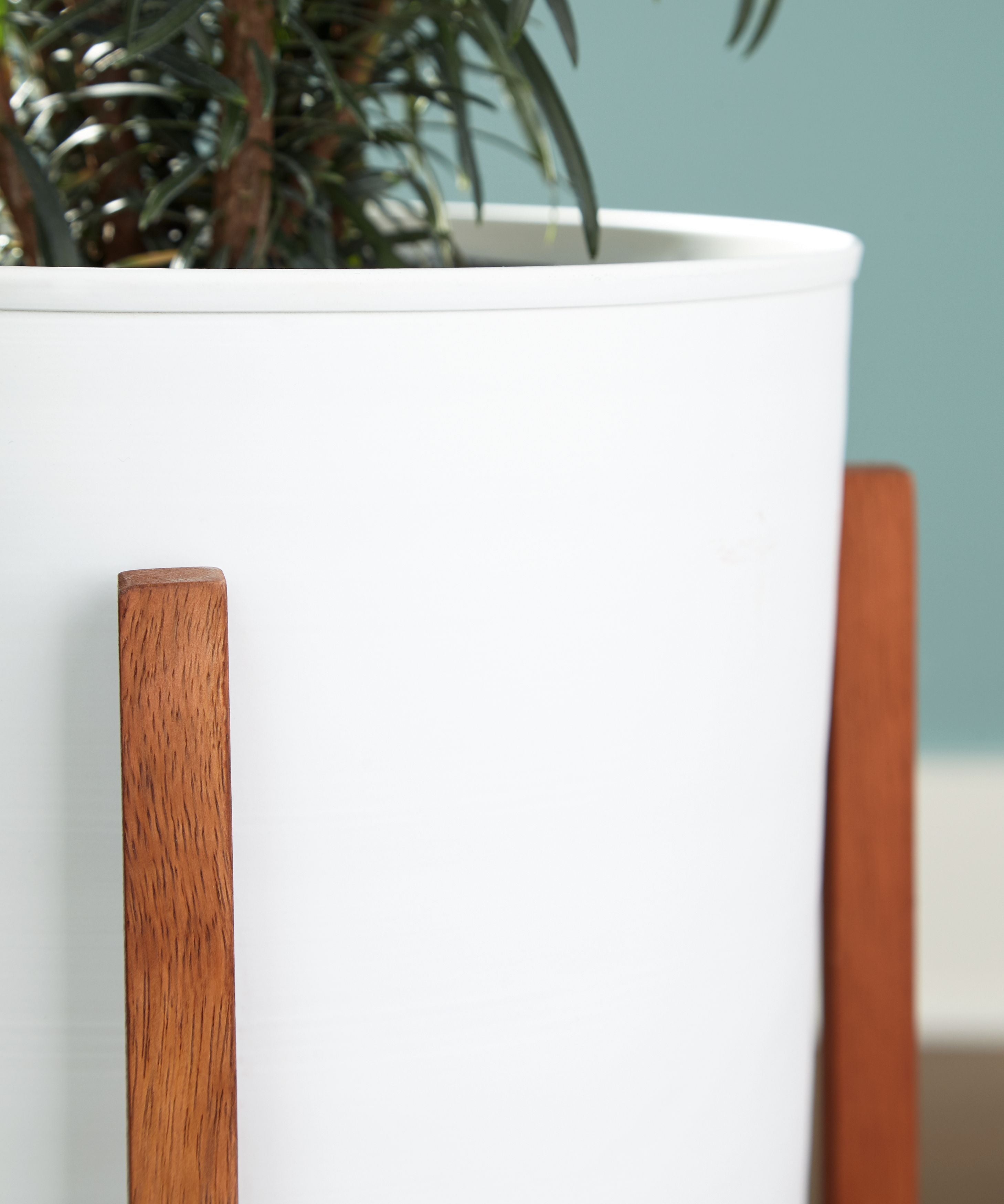 White planter pot with brown wooden side supports