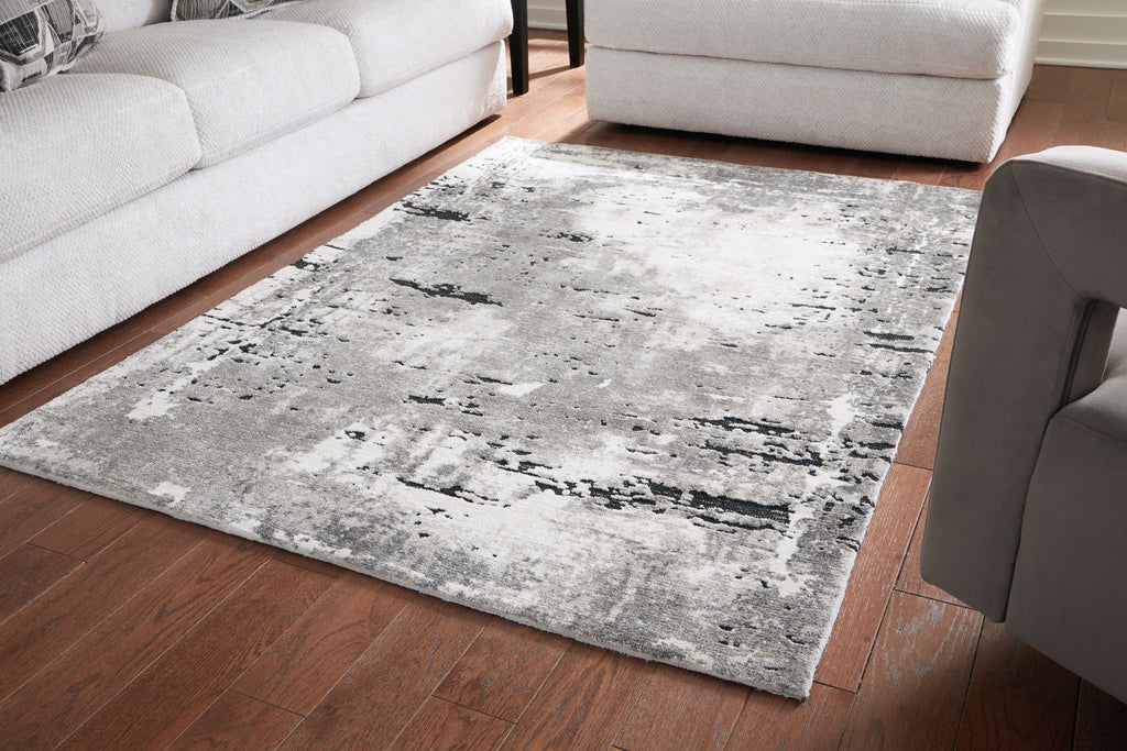 Gray area rug with distressed black speckle pattern, rectangular shape