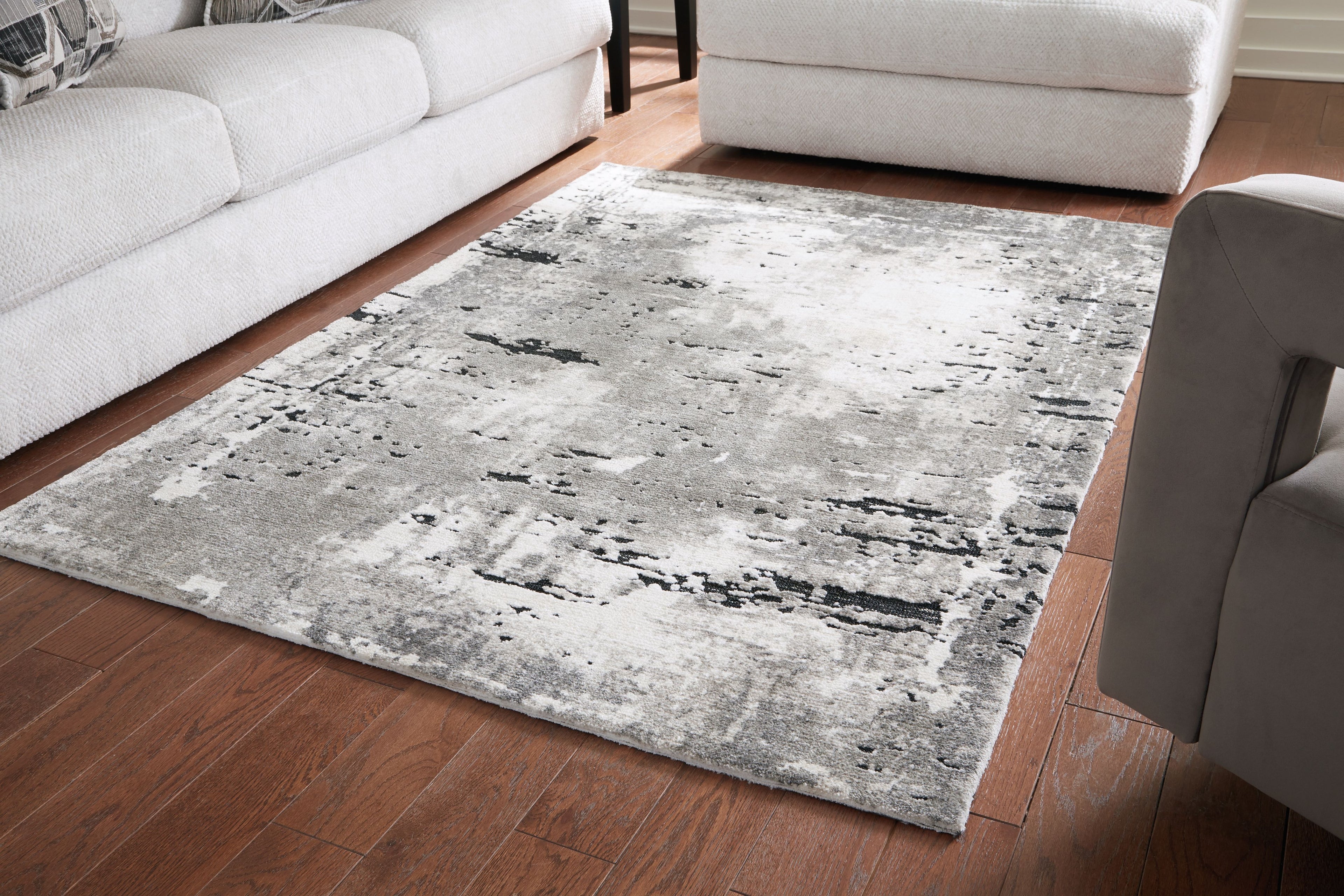 Gray area rug with distressed black speckle pattern, rectangular shape