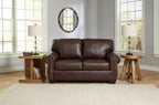 Dark brown loveseat with cushioned back and nailhead-trimmed arms