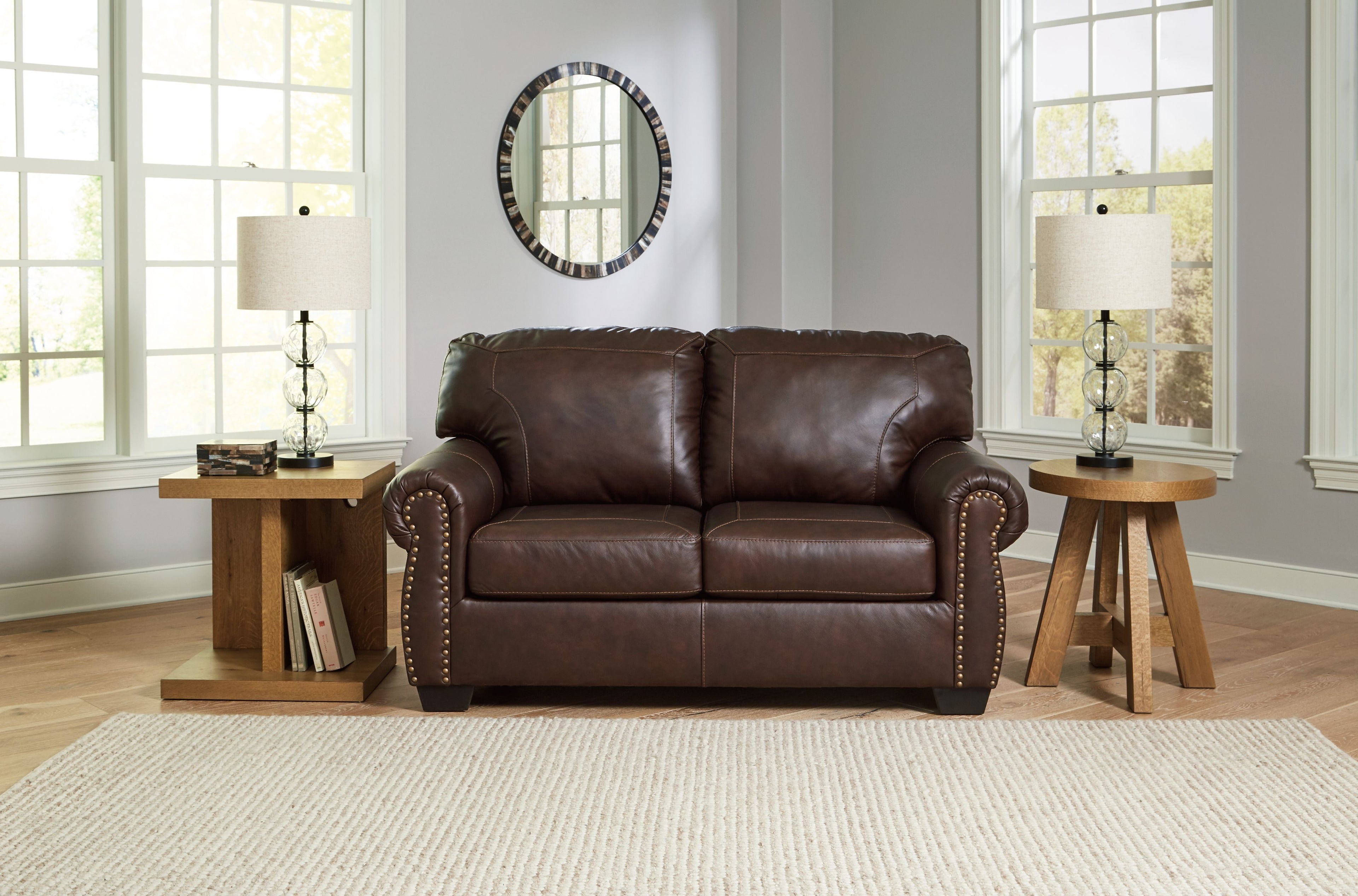 Dark brown loveseat with cushioned back and nailhead-trimmed arms