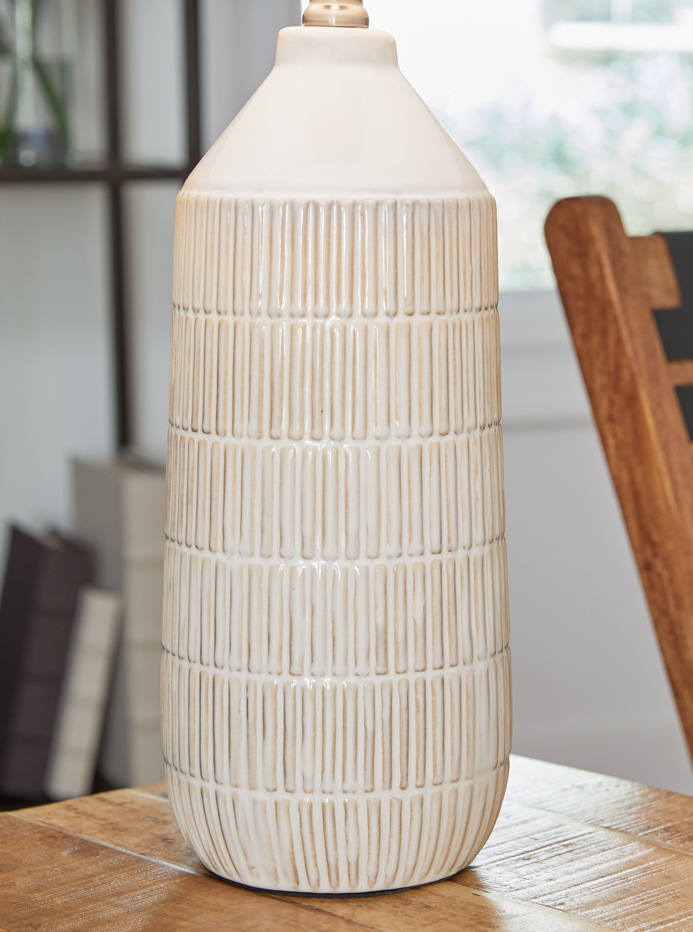 Ceramic table lamp with off-white fabric drum shade and ridged ceramic base