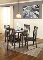 Dark brown round dining table set with four slat-back chairs and black padded seats