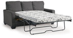 Dark gray sofa bed with pulled-out mattress and floral patterned cover