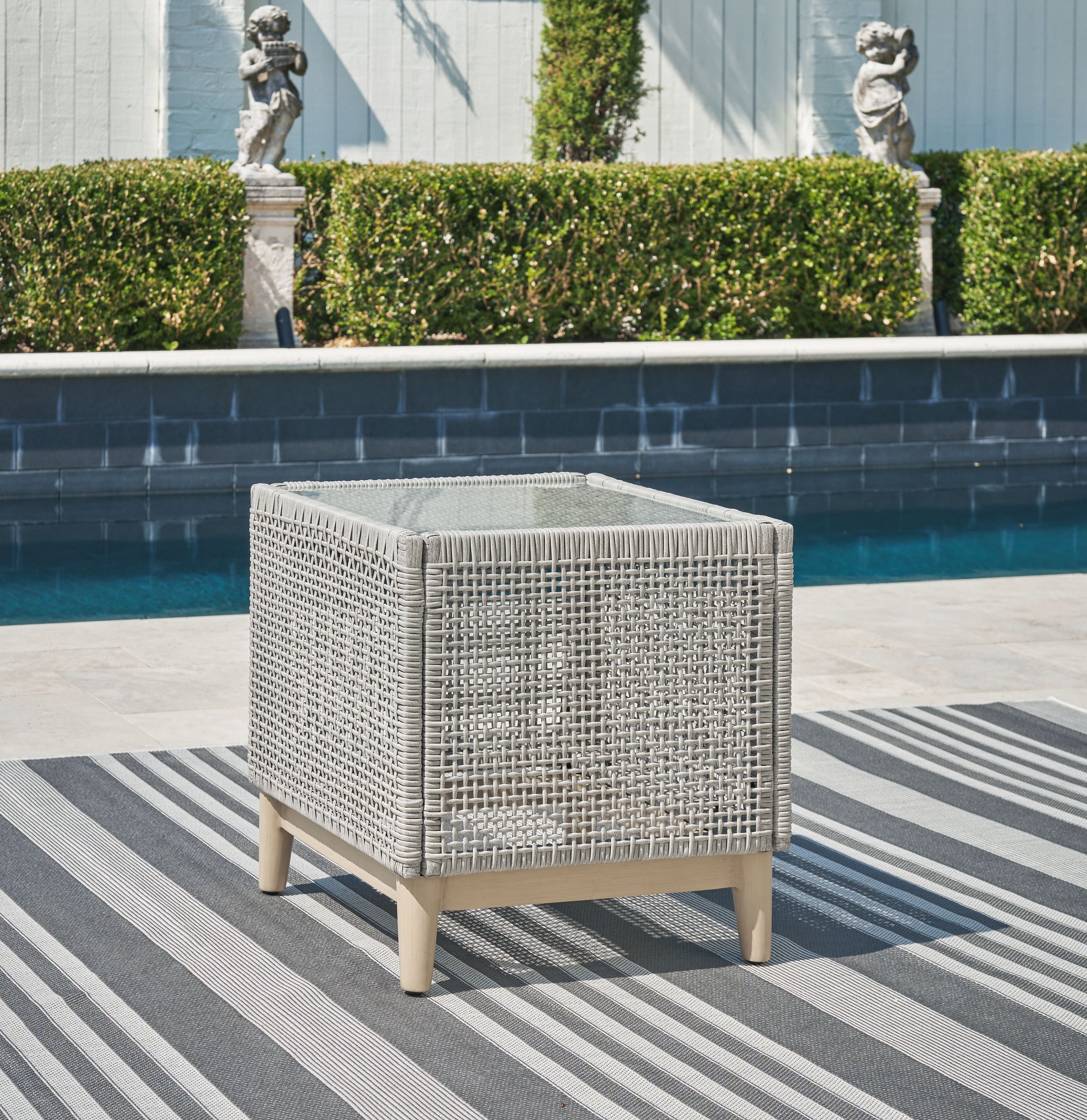 Gray wicker square end table with open weave design and tapered wood feet