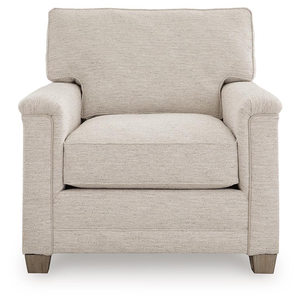 Light beige upholstered armchair with tall backrest, rolled arms, and wooden legs