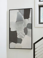 Framed abstract wall art with gray and white rectangles, black frame on a wall