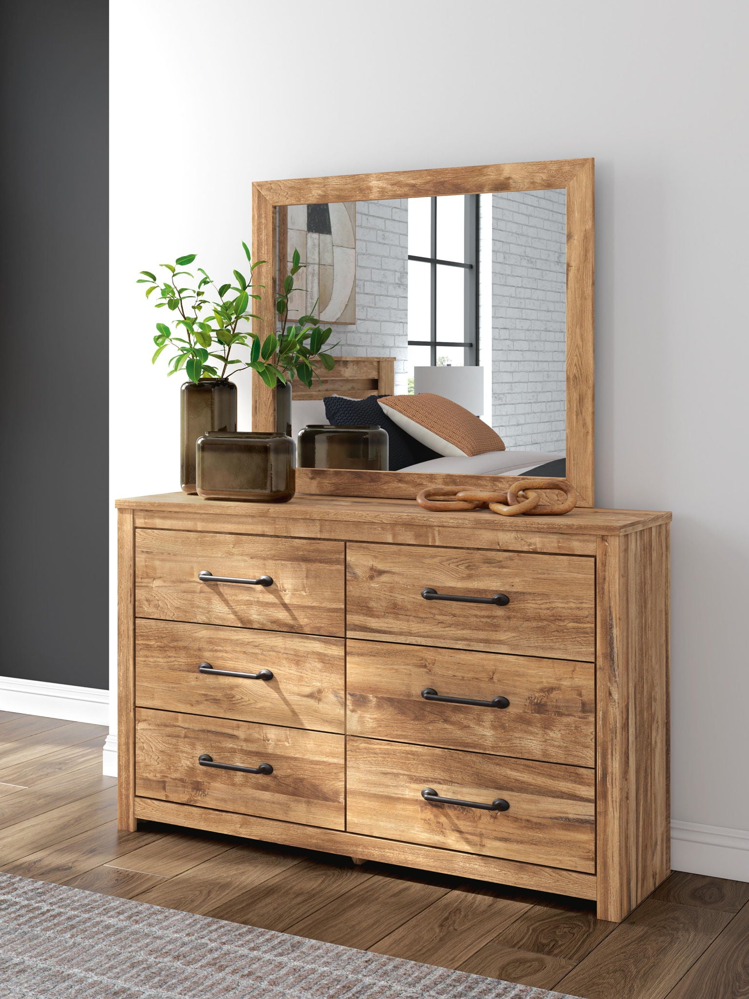 Light brown six-drawer dresser with square mirror and black bar pulls on flat top.
