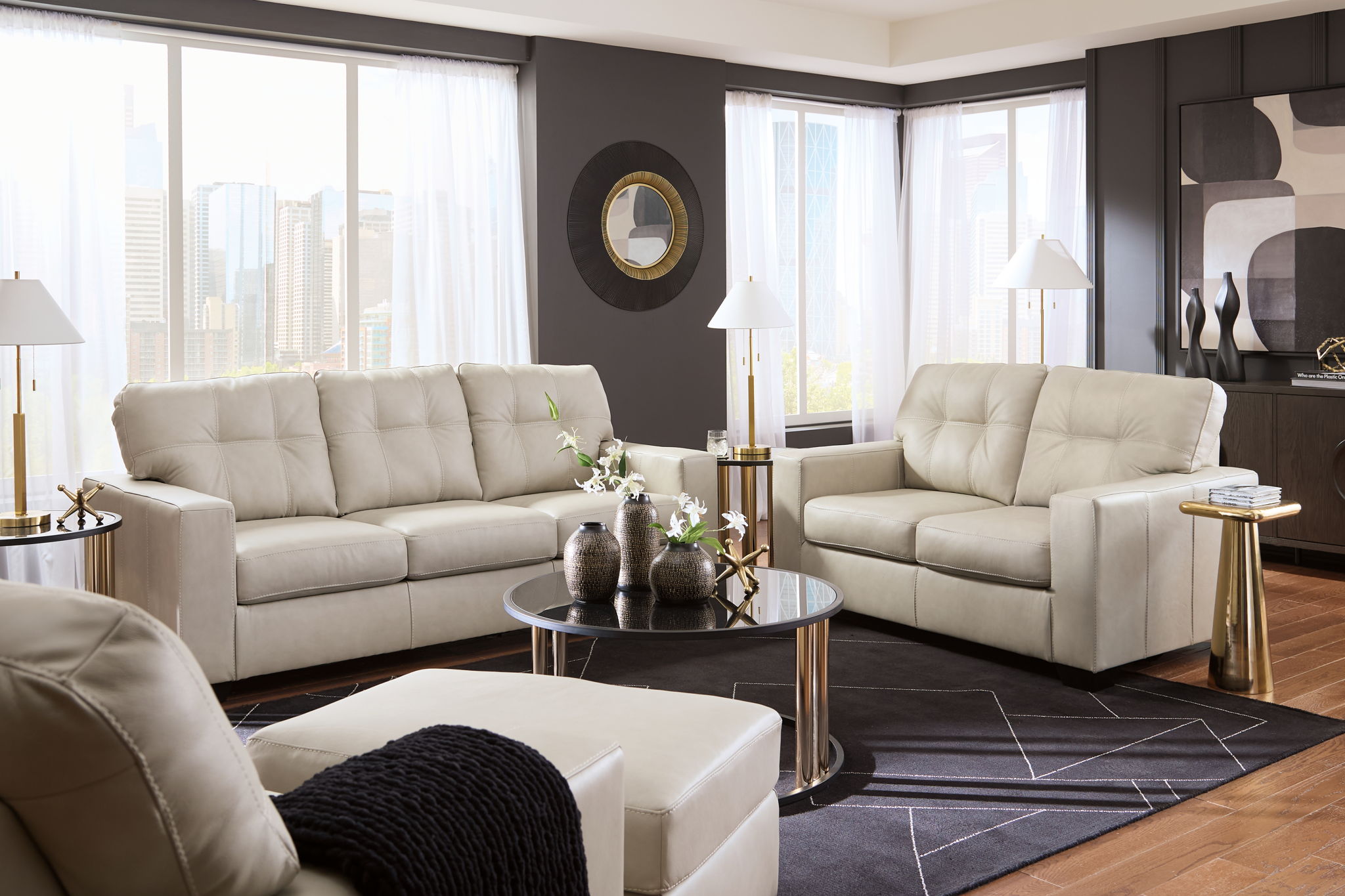 Beige upholstered sofa and loveseat set with tufted backs, wide room view