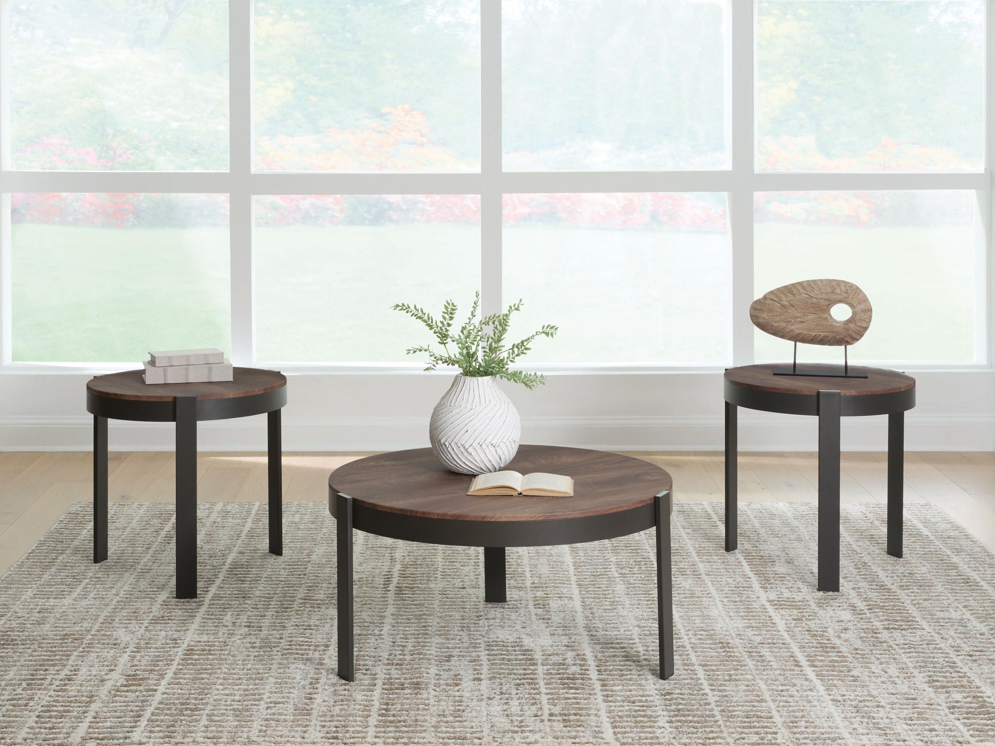 Set of three round occasional tables with brown tops and black metal legs