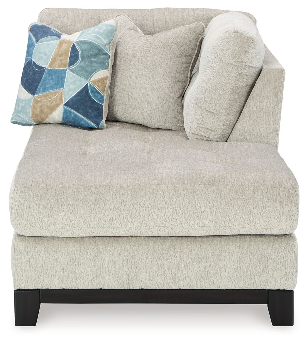 Stone corner chaise with tufted back, dark legs, and geometric throw pillow