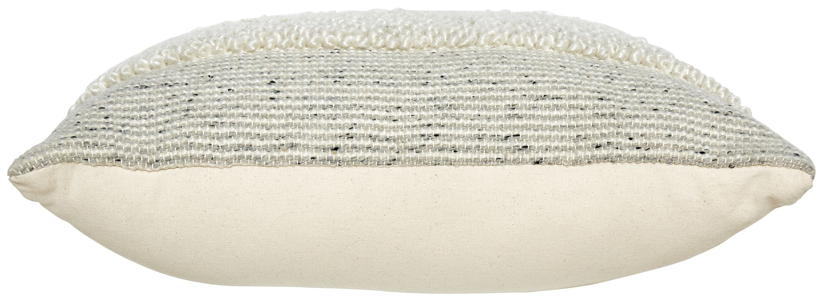 Textured cream pillow with piped edge and rounded seam profile