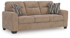 Light brown sofa with three seat cushions and two striped lumbar pillows
