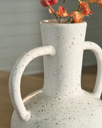 Speckled white ceramic vase with red flowers and two loop handles.