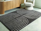 Eldonmore rug with black ground and white contour lines in bold V-shaped curves.