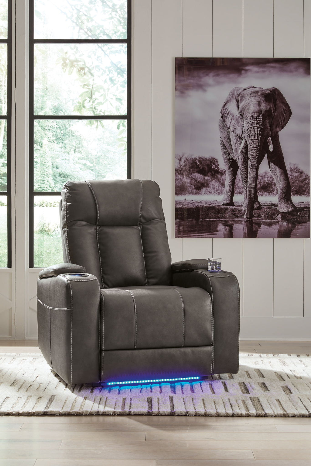 Dark power recliner chair with tall back and adjustable headrest, upright