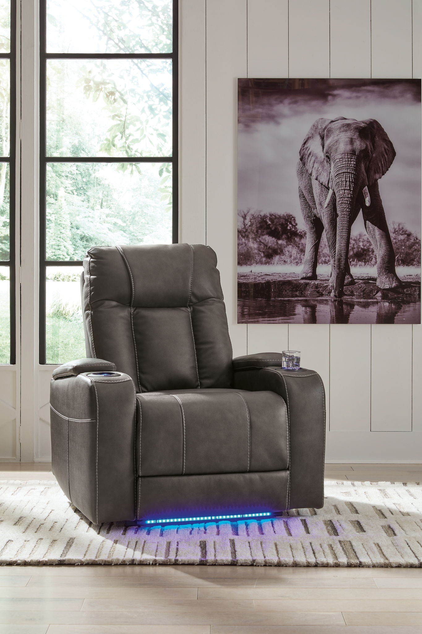 Dark power recliner chair with tall back and adjustable headrest, upright