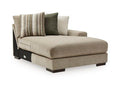 Beige upholstered corner chaise with dark legs and striped accent pillows