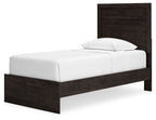 Panel bed with dark wood headboard and footboard, white mattress with pillow