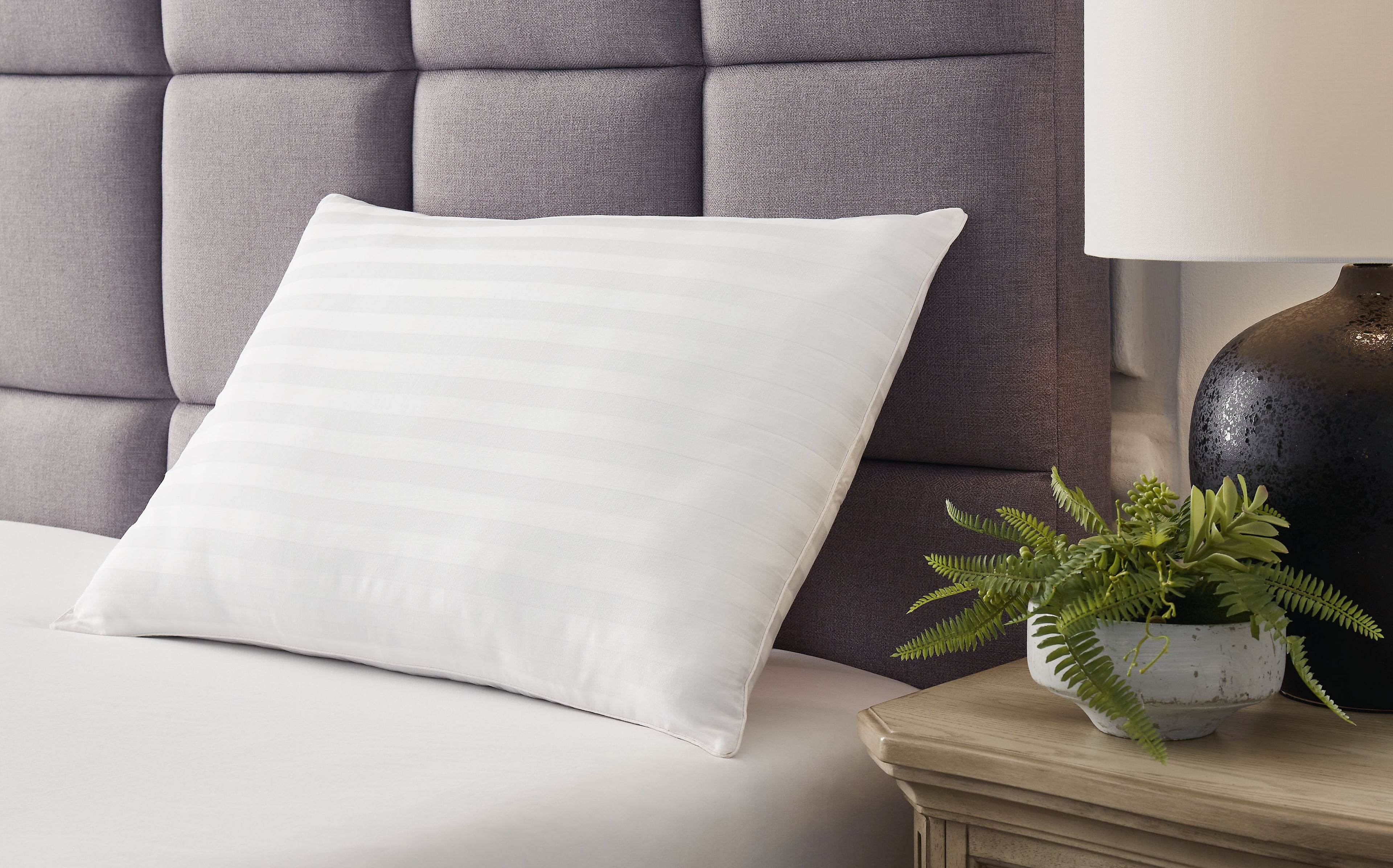 White cotton pillow set on bed, square shape, subtle stitched stripe texture