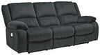 Draycoll reclining sofa in slate with tufted cushions, track arms, and reclining head support