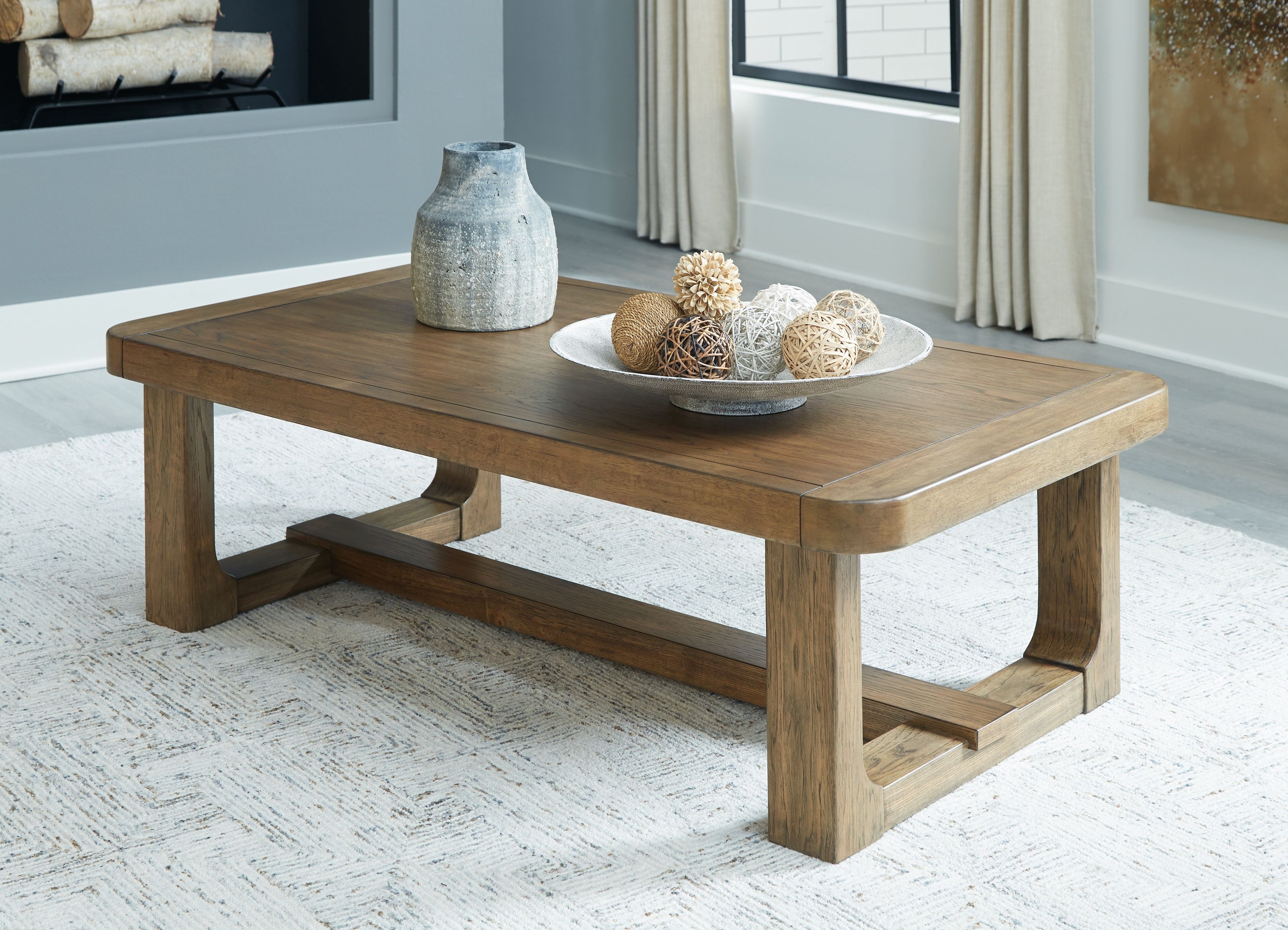Rectangular light brown wood cocktail table with lower shelf and thick legs