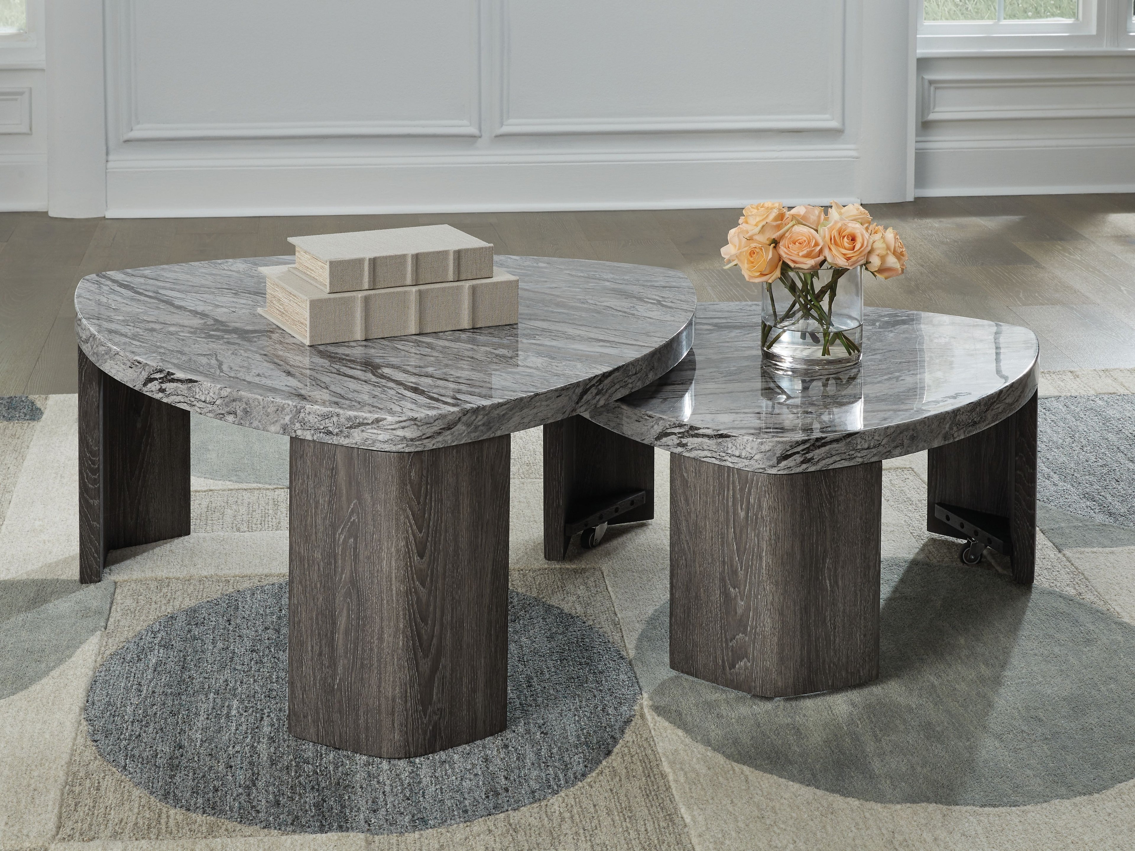 Pair of round nesting cocktail tables with gray marbled tops and thick gray pedestal bases