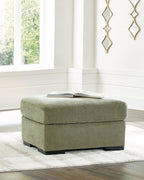 Green upholstered ottoman with square padded seat and black legs