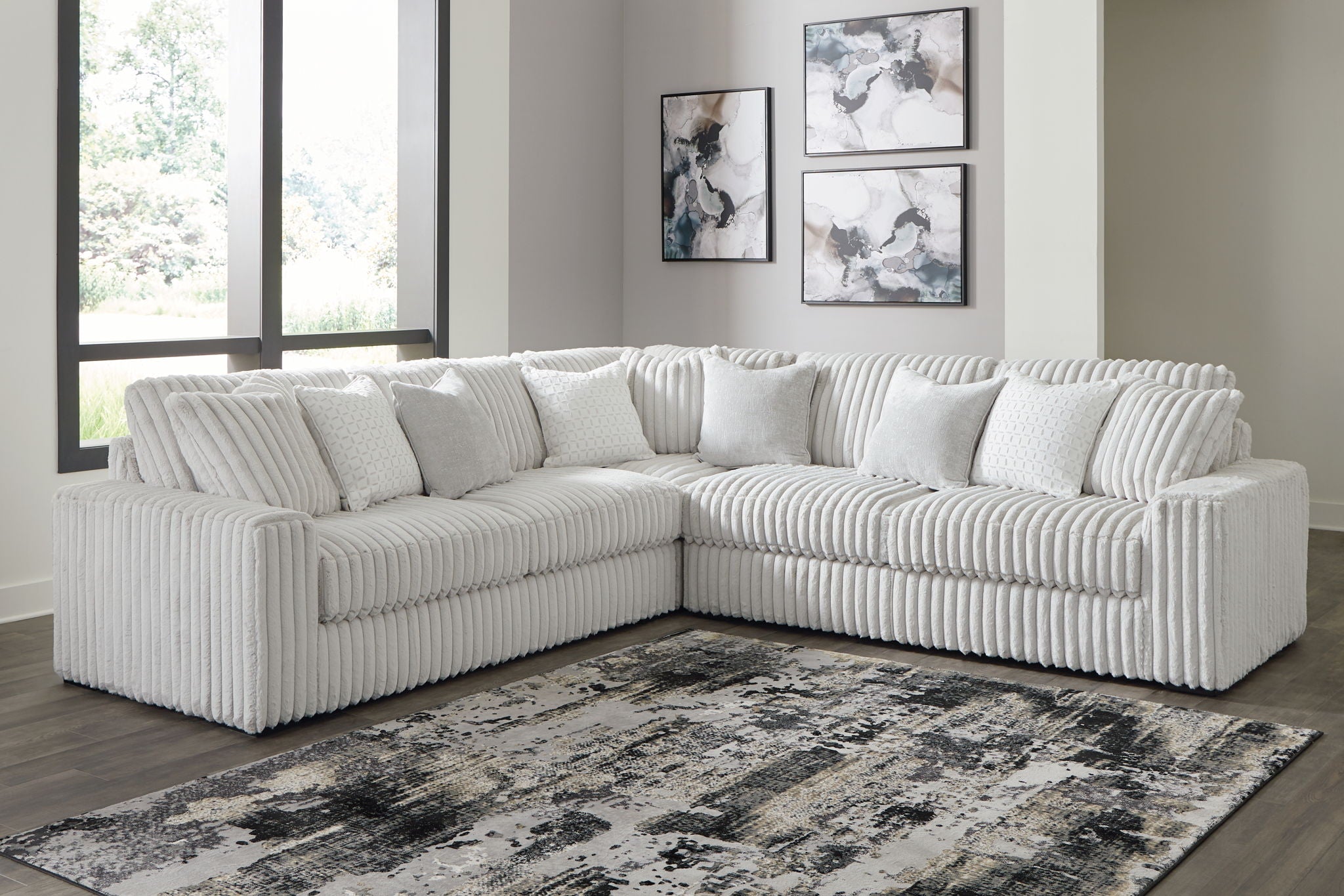 Gray sectional sofa with oversized chaise, tufted back pillows and ribbed texture