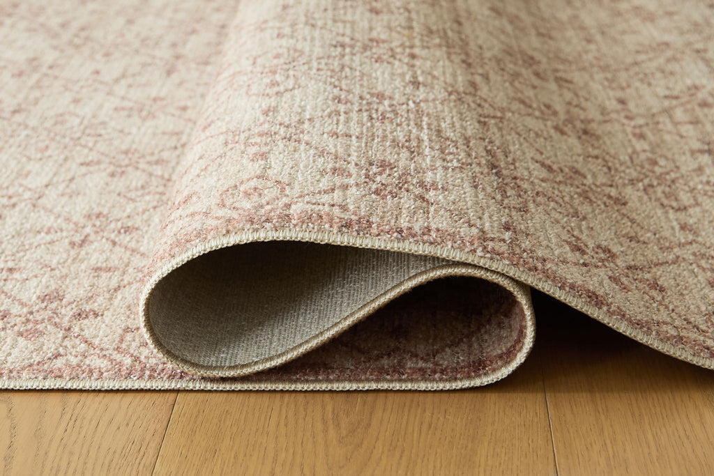 Area rug with rolled edge showing beige top and gray underside backing
