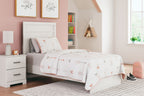 Light wood panel bed with headboard, patterned blanket, and white mattress