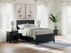 Black panel bed with footboard drawers and paneled headboard; gray bedding and lamp