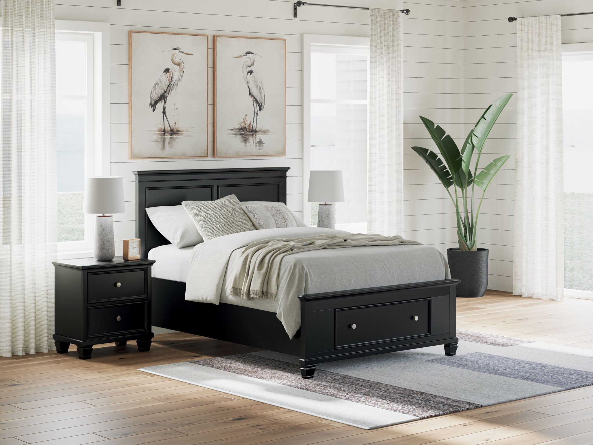 Black panel bed with footboard drawers and paneled headboard; gray bedding and lamp