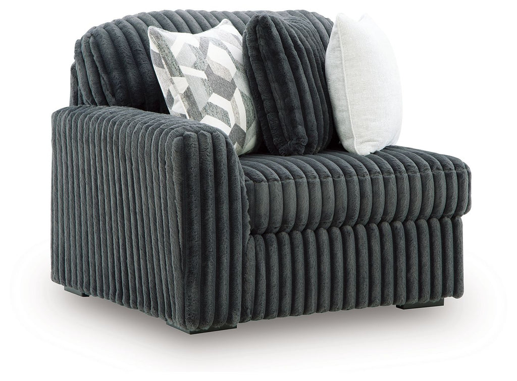 Gunmetal ribbed velvet corner chair with thick armrest and two throw pillows