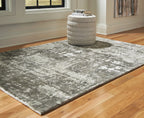 Dark gray area rug with distressed pattern, flatwoven look, and textured surface