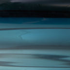 Teal blue glass bowl close-up, glossy surface and rim detail