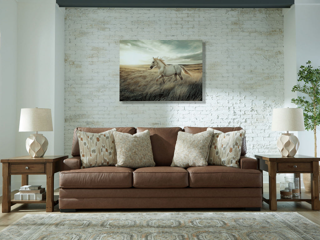 Caramel brown sofa with patterned lumbar pillows and matching textured throw cushions