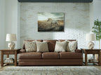 Caramel brown sofa with patterned lumbar pillows and matching textured throw cushions