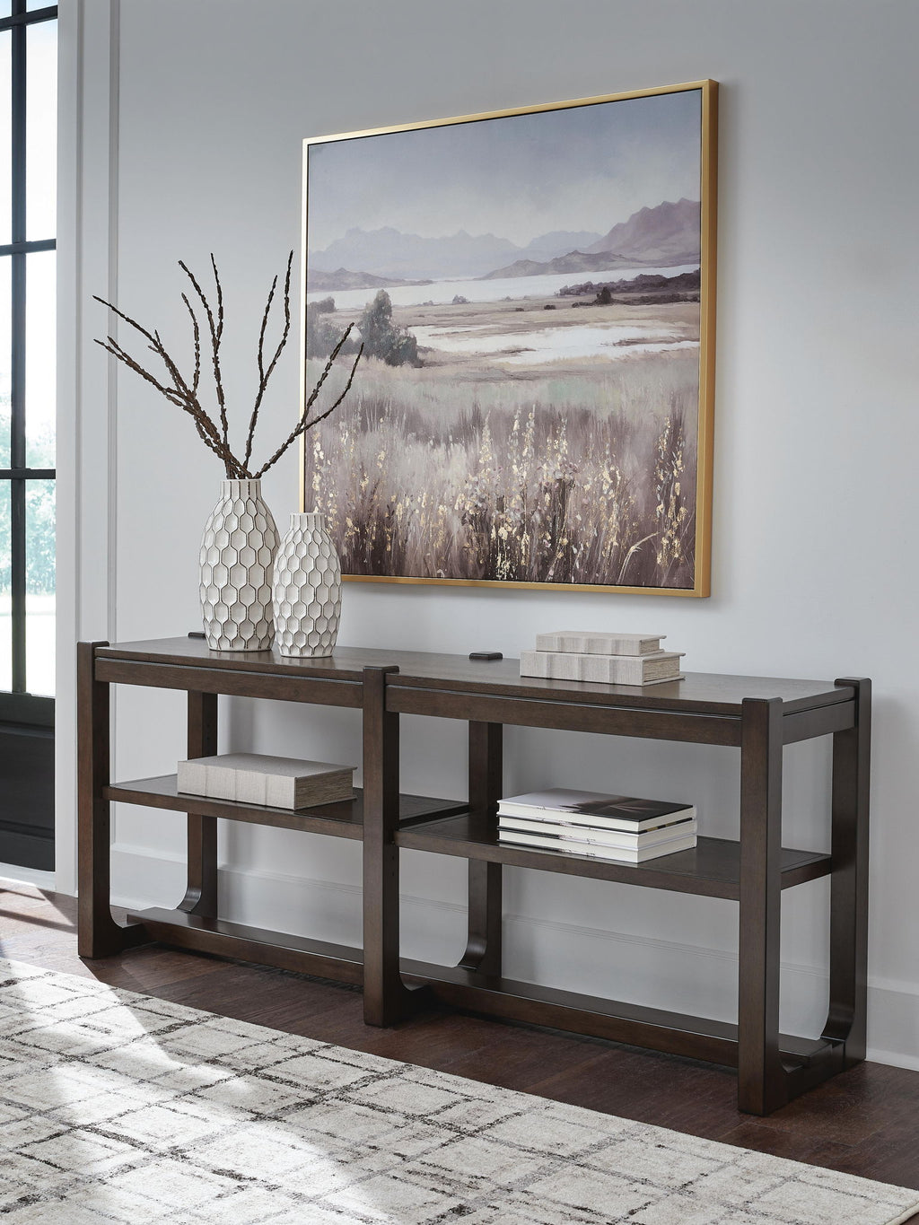 Dark brown sofa table with two shelves and decorative items on top